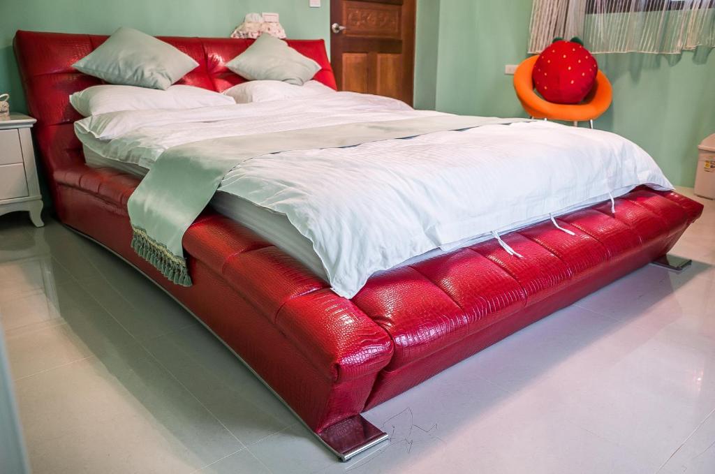 a red bed in a room with a red leather bed frame at Xinyue B&amp;B in Fenglin