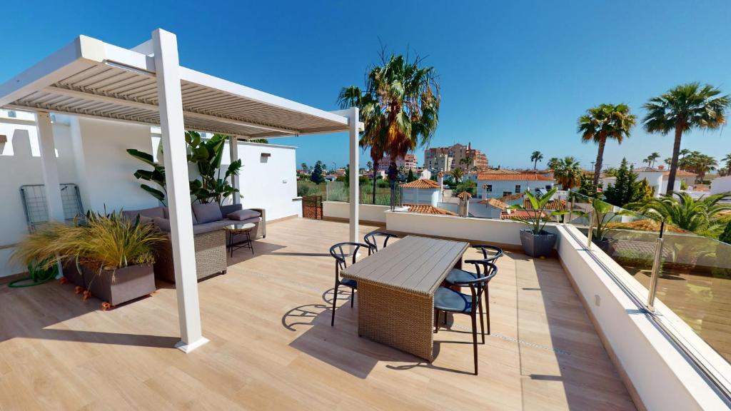 a patio with a table and chairs on a roof at Sunrise by ON Travel in Oliva