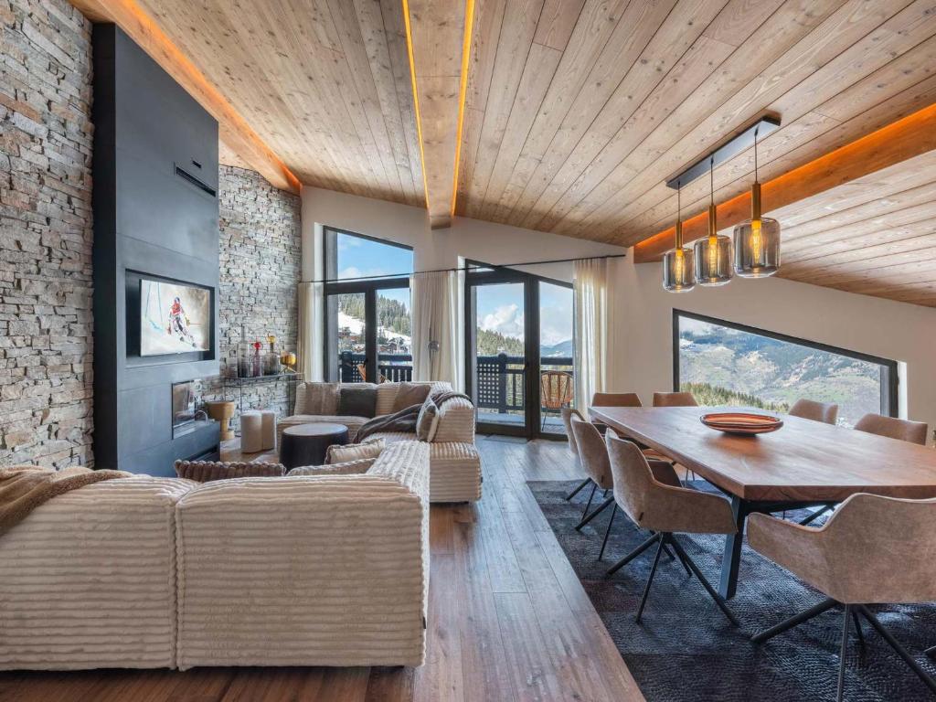 une salle à manger et un salon avec une table et des chaises dans l'établissement Duplex Neuf Ski In/Out avec Spa et Piscine à Courchevel 1850 - FR-1-564-99, à Courchevel