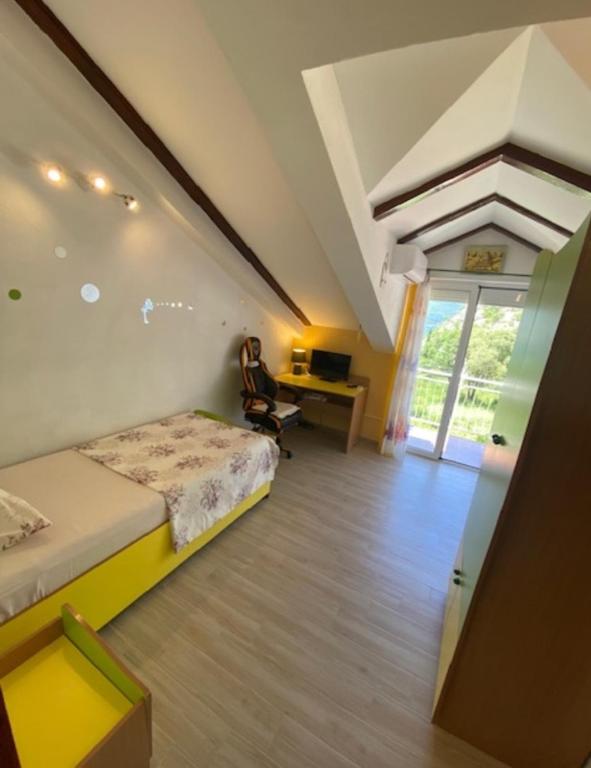 a bedroom with a bed and a desk with a computer at Lux apartmani Darija in Kotor