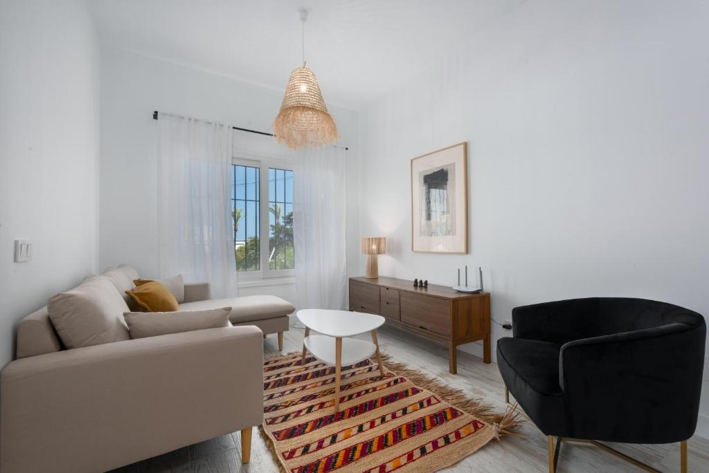 una sala de estar con un sofá y una silla en Torreguadiaro flat - 2 min to beach, en San Roque