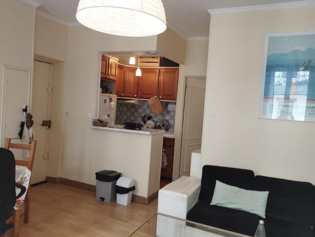 un salon avec un canapé blanc et une cuisine dans l'établissement Cosy appartement next to Olympic sites, à Paris