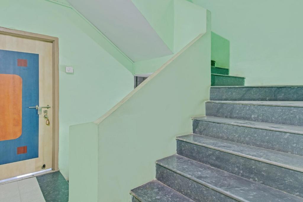 a staircase in a building with a blue door at SPOT ON Sahara Yatri Niwas in Kolhapur