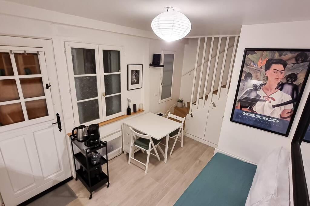 une chambre avec une table et une affiche de cinéma sur le mur dans l'établissement Duplex Paris, à Paris