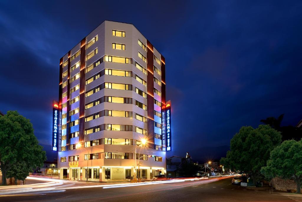 a tall white building at night with a street at Shiny Ocean Hotel in Hualien City