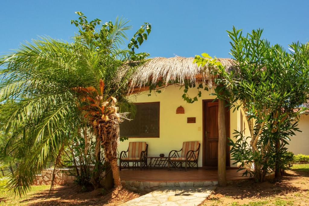 ein kleines Haus mit einem Strohdach und einer Veranda in der Unterkunft Mbuni Granja de Avestruz in Nueva Colombia