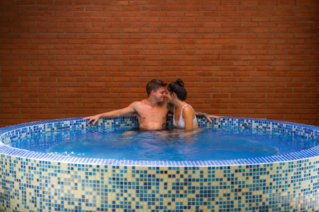 um homem e uma mulher em uma piscina em Grinbergs Village Hotel em Socorro