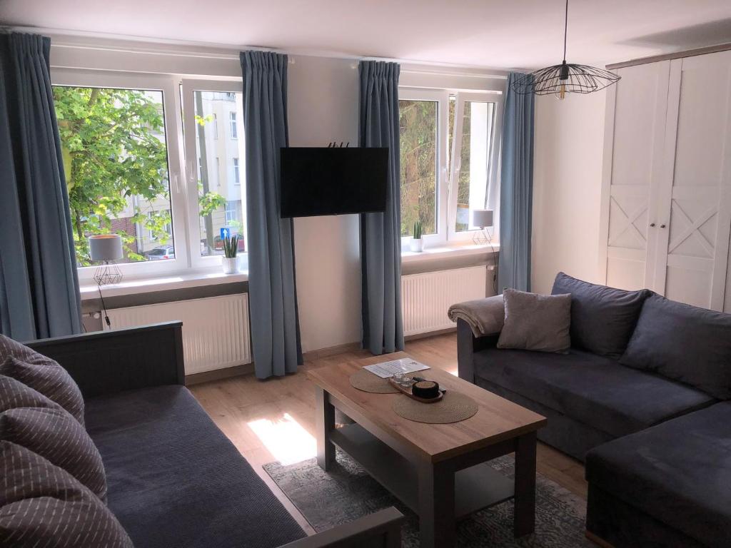 a living room with a couch and a table at Apartament Promyk in Świnoujście