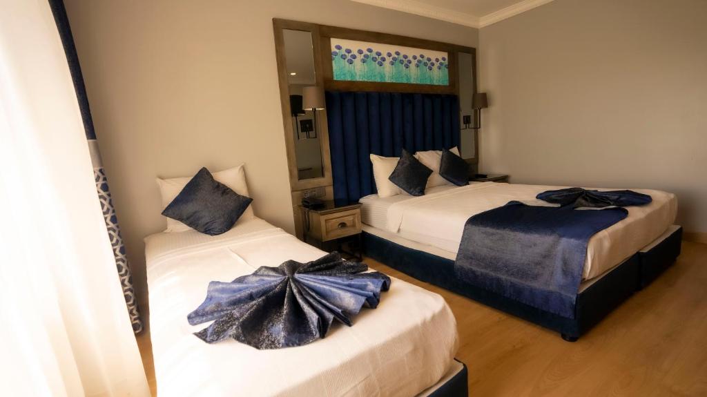 a bedroom with two beds with blue bows on them at Farina Hotel By Cigno in Istanbul