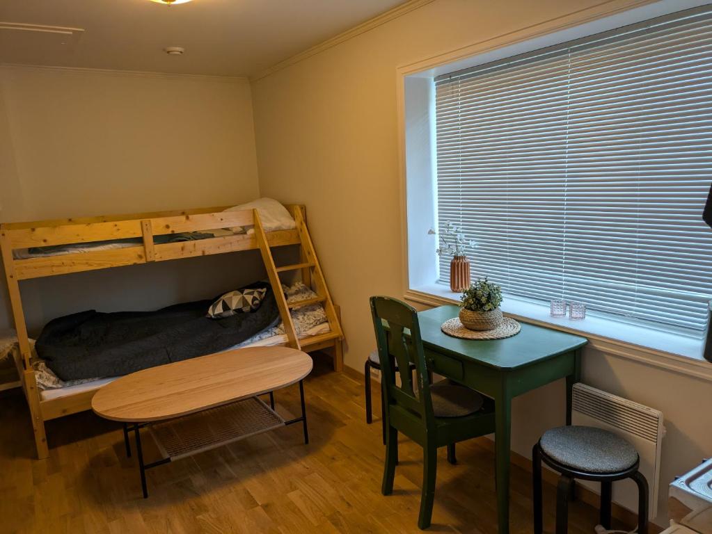 a bedroom with a bunk bed and a table and a desk at Leilighet sentralt i Stryn in Stryn