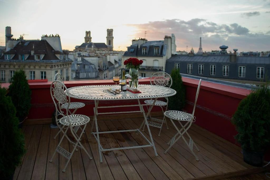 une table et des chaises sur un balcon avec vue dans l'établissement Amazing Rooftop Odeon Luxembourg, à Paris