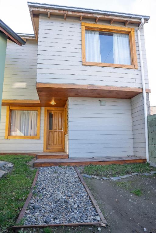 a white house with a door and a driveway at Happy Guest Apart 87 in Ushuaia