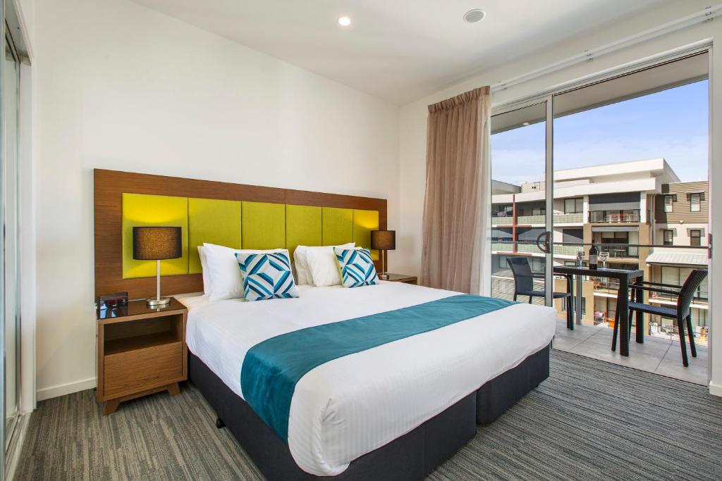 a hotel room with a large bed and a balcony at Quest Chermside on Playfield in Brisbane