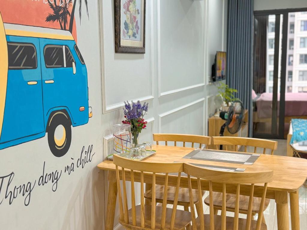 a dining room with a table and a van on the wall at Boom'homes- Căn hộ view Vịnh Hạ Long in Ha Long