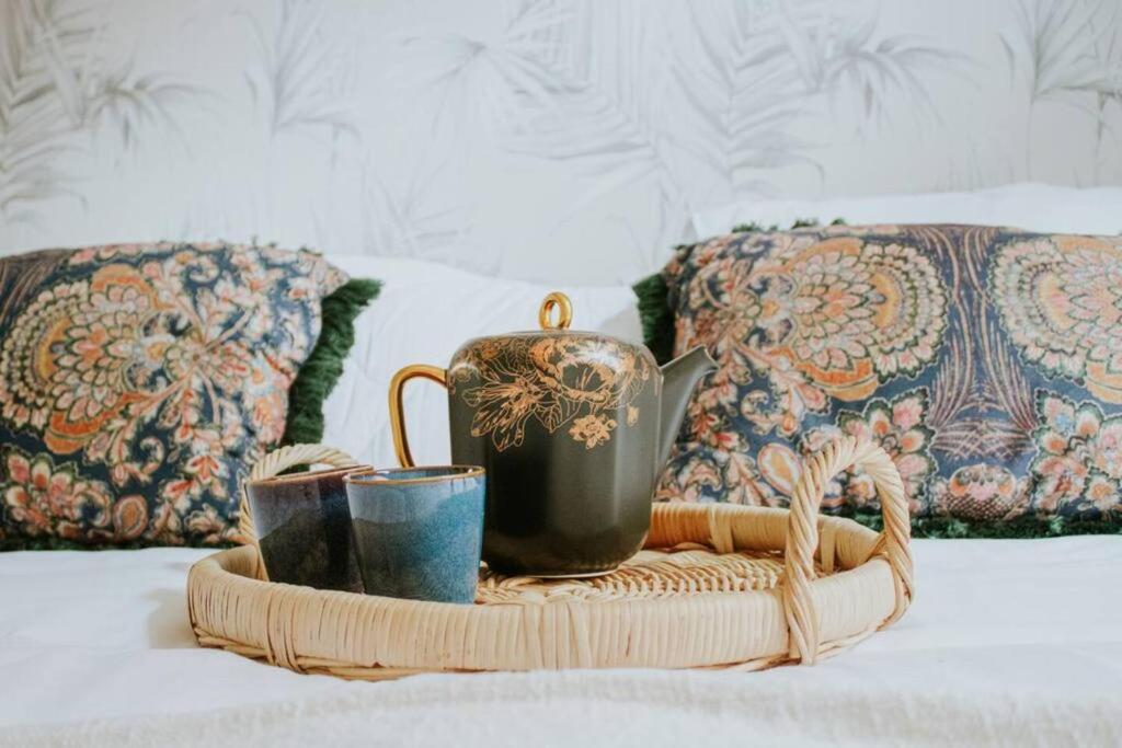 a tray with a tea pot and cups on a bed at Boutique 2br Apt With Garden At Fontys in Tilburg