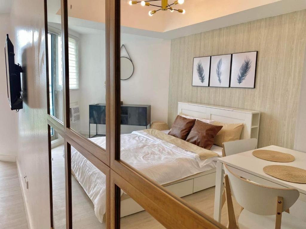 a small bedroom with a bed and a table at Modern & Minimalist Space Azure North Residences in San Fernando