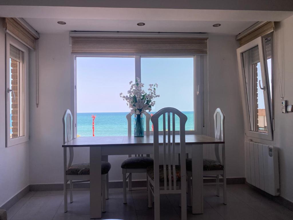 Una mesa de comedor con vista al mar. en Apartamento en Paseo Maritimo, en Vinarós
