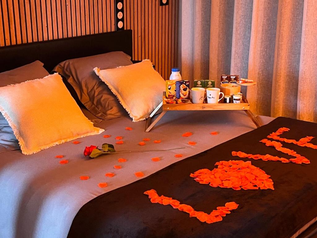 un lit avec une table avec des fleurs orange dessus dans l'établissement Cocon détente pour 2 avec hammam et jacuzzi privé Mer Lac, au Barcarès