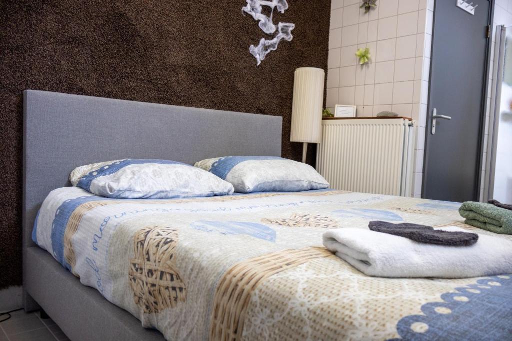 een slaapkamer met twee bedden met handdoeken erop bij Voormalige Gevangenis Cel bij B&B Gezond aan Zee - Toegang Wellnesstuin meerprijs in Ouddorp
