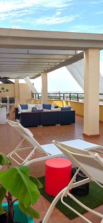patio z krzesłami i kanapą na dachu w obiekcie Atico Torremolinos w mieście Torremolinos