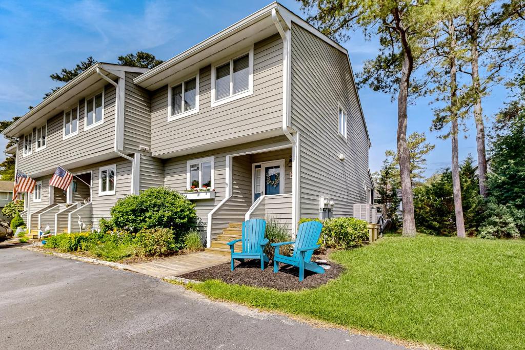 a house with two blue chairs in front of it at Westwood --- 828 Westwood Unit D in Bethany Beach