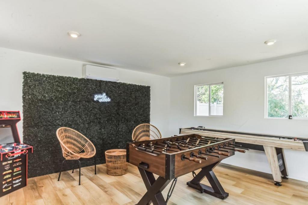a room with a ping pong table and chairs at Modern Log Cabin at the beach with Hot Tub, Game Room and Fire Pit in Del Haven
