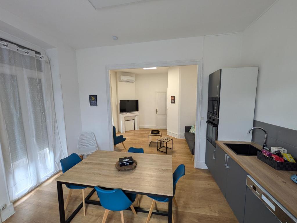 une cuisine et une salle à manger avec une table et des chaises dans l'établissement Maison de ville Marmande, à Marmande