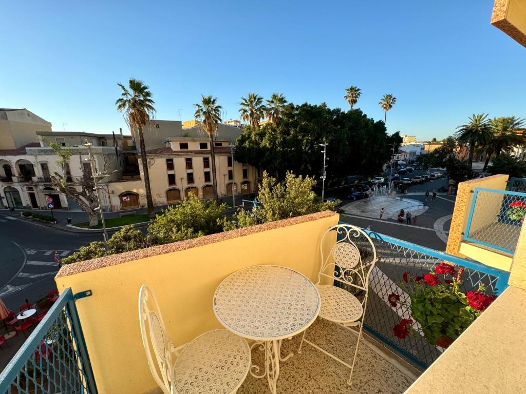 a balcony with tables and chairs on a city street at Feel Boutique Rooms in Oristano