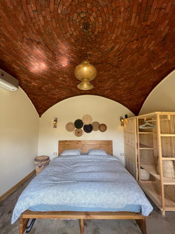 a bedroom with a bed and a wooden ceiling at Mannam guesthouse & beautiful garden in Dahab