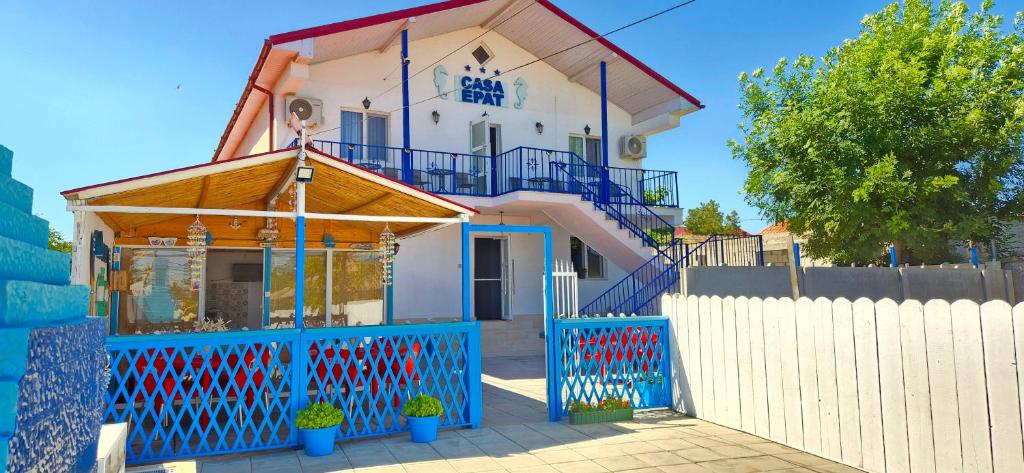 a house with a blue fence in front of it at Casa Epat in 2 Mai