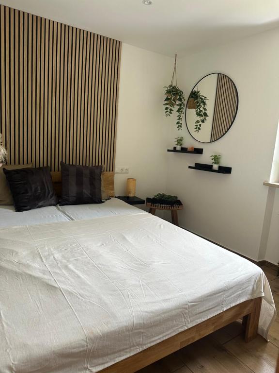 een slaapkamer met een wit bed en een spiegel bij Fewo Auszeit am Königssee in Schönau am Königssee