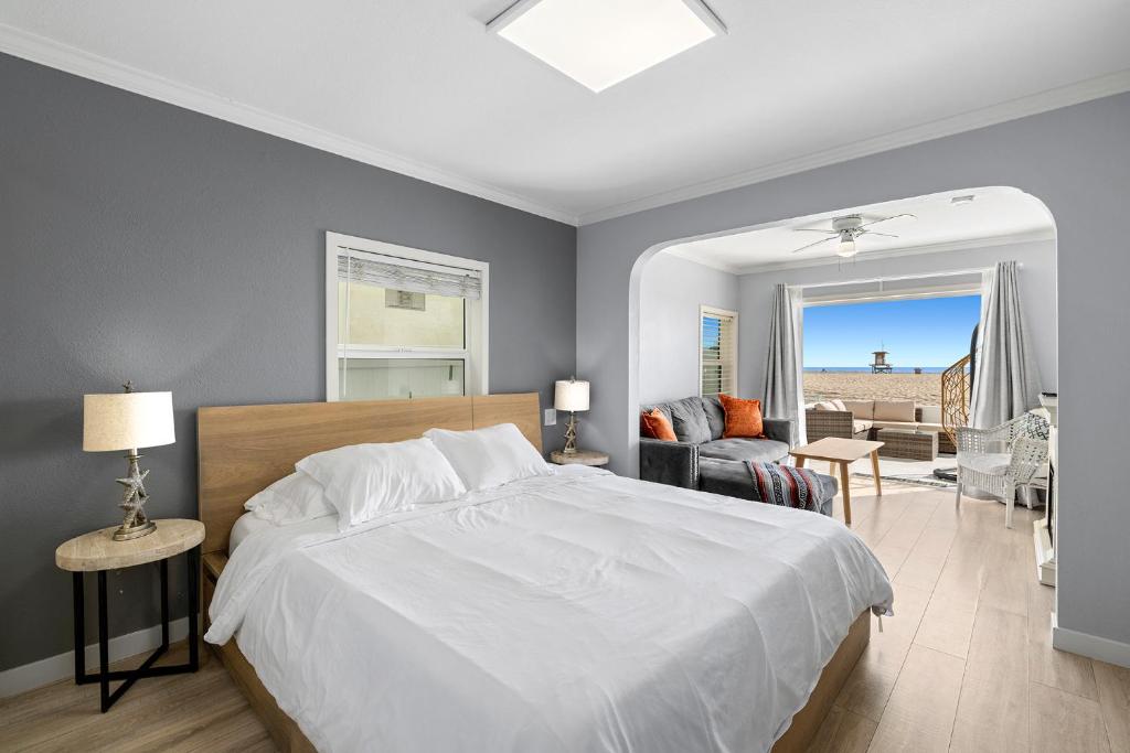 a bedroom with a white bed and a living room at 1628 West Oceanfront Oasis 2,3 in Newport Beach