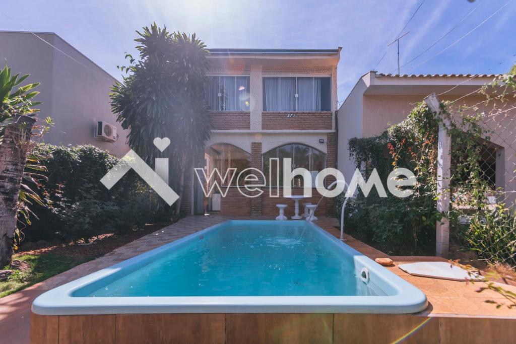 a villa with a swimming pool in front of a house at Casa com piscina em Buritama in Buritama