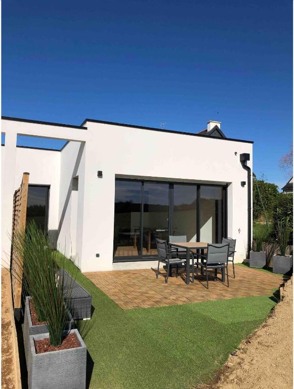 une maison blanche avec une table et des chaises dans l'établissement La villa Pontivyenne, à Noyal-Pontivy