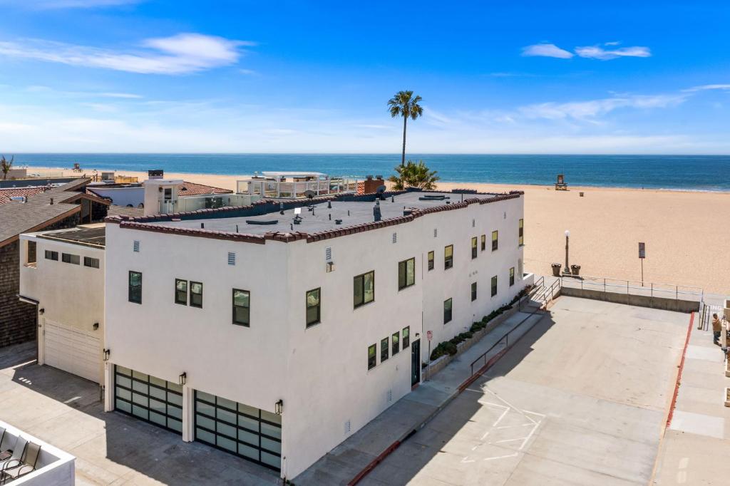 an aerial view of a white building next to the beach at West Oceanfront Oasis 4 in Newport Beach
