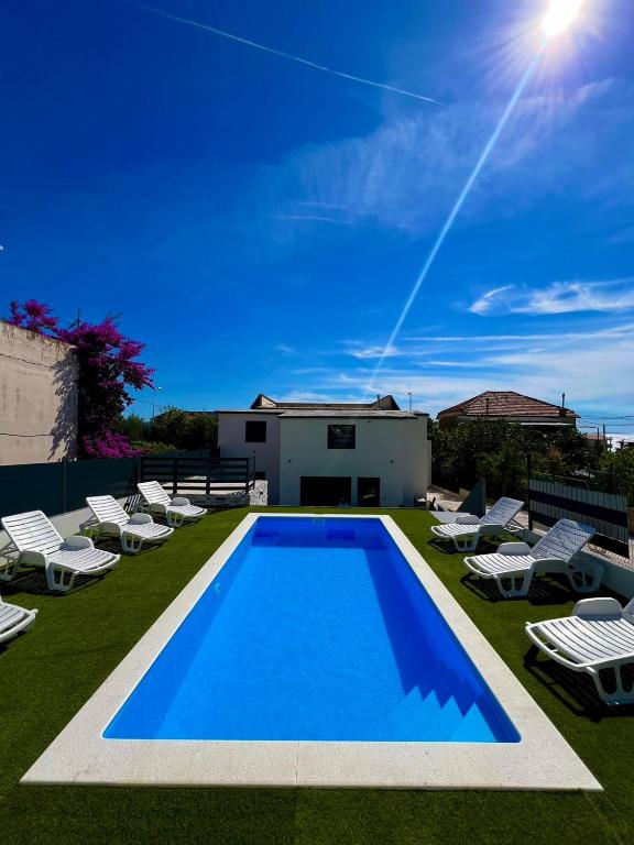 a swimming pool with lawn chairs and a house at Villa paradise in Podstrana