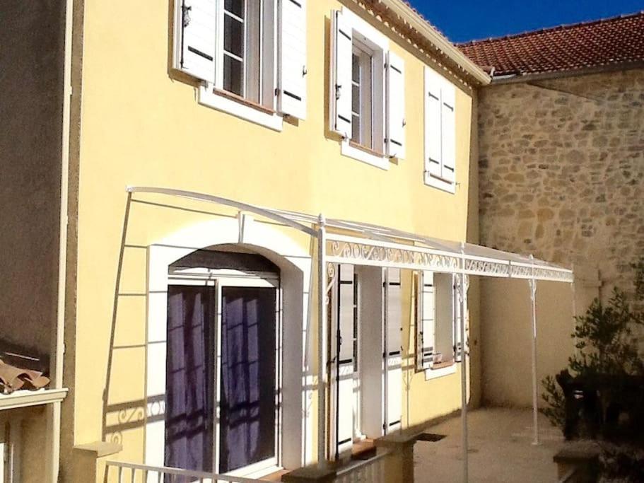 un bâtiment en construction avec une arche et des fenêtres dans l'établissement Maison jaune, à Aimargues