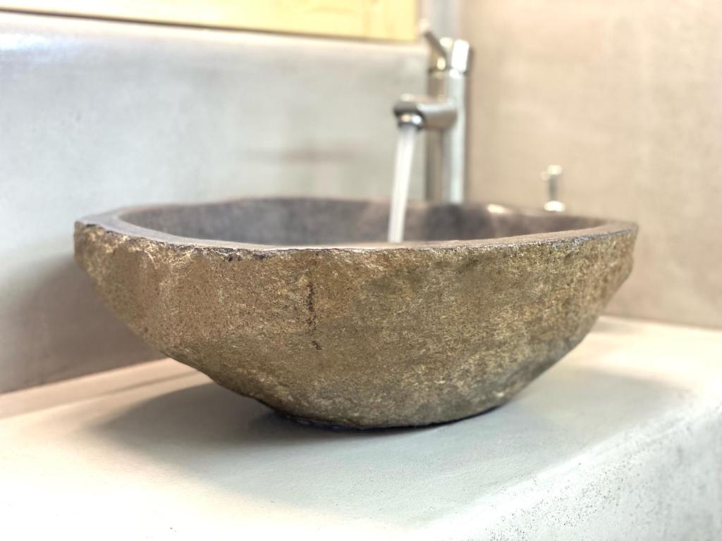 a stone sink sitting on a counter in a bathroom at Agia Kyriaki Studios in Agia Kiriaki Beach