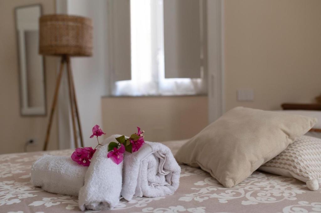 a bedroom with towels and flowers on a bed at Sapore di Sale in Salerno