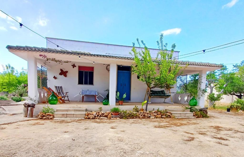 a small white house with a blue door at Casina La Tajata in Manduria