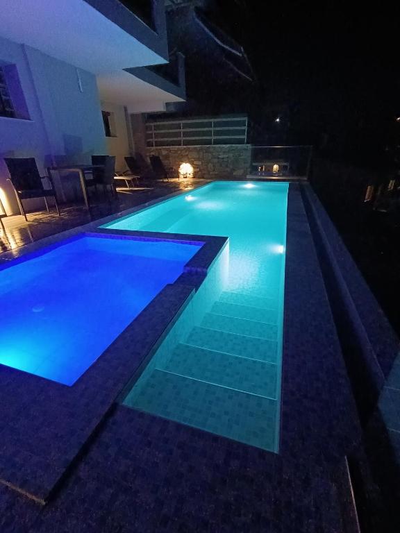 a large swimming pool at night with blue illumination at ALTA MARE in Nea Peramos