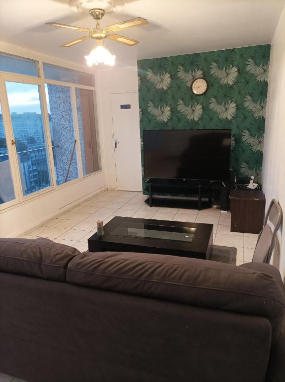 un salon avec un canapé et une télévision à écran plat dans l'établissement Joli appartement entier, à Vitry-sur-Seine