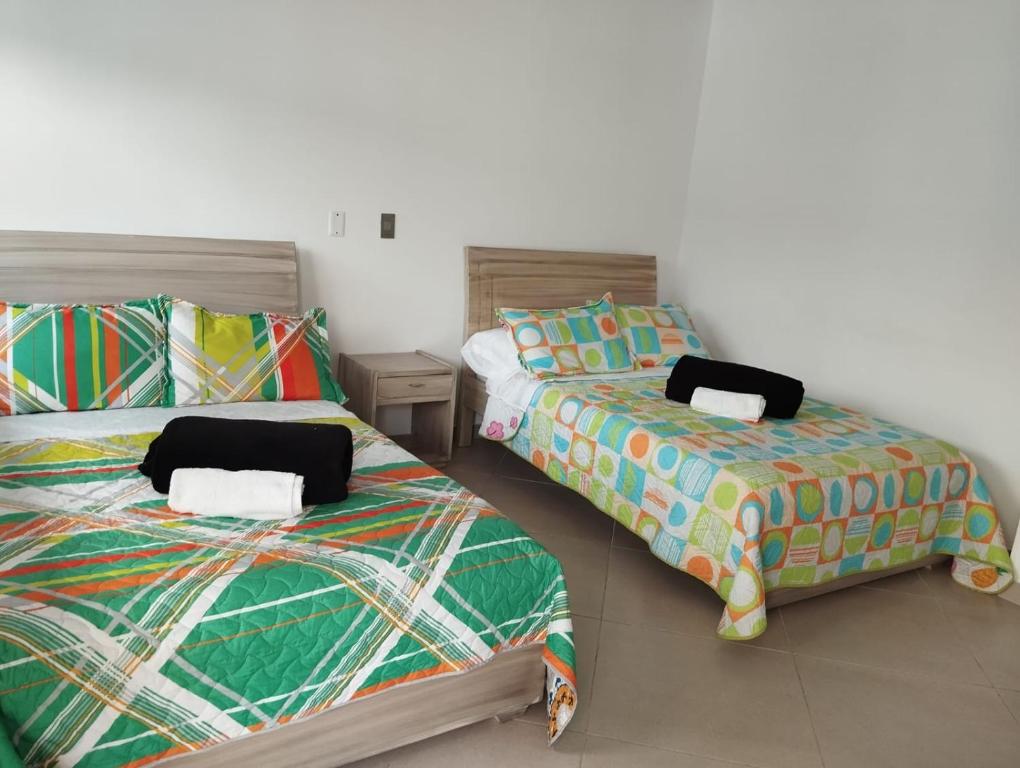 two beds sitting next to each other in a room at HOTEL GLASS LAS VEGAS in La Vega