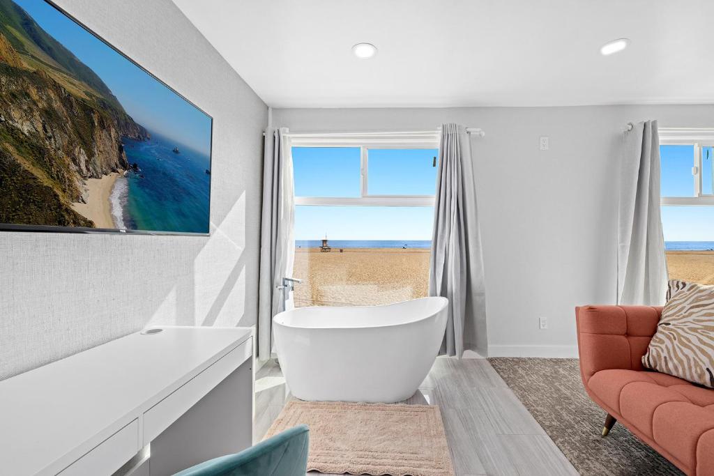 a bathroom with a tub and a chair and a window at 1628 West Oceanfront Oasis 8 in Newport Beach