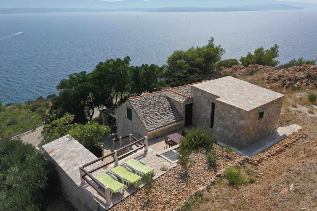 an aerial view of a house on a hill next to the ocean at House Bepo in Nerežišće