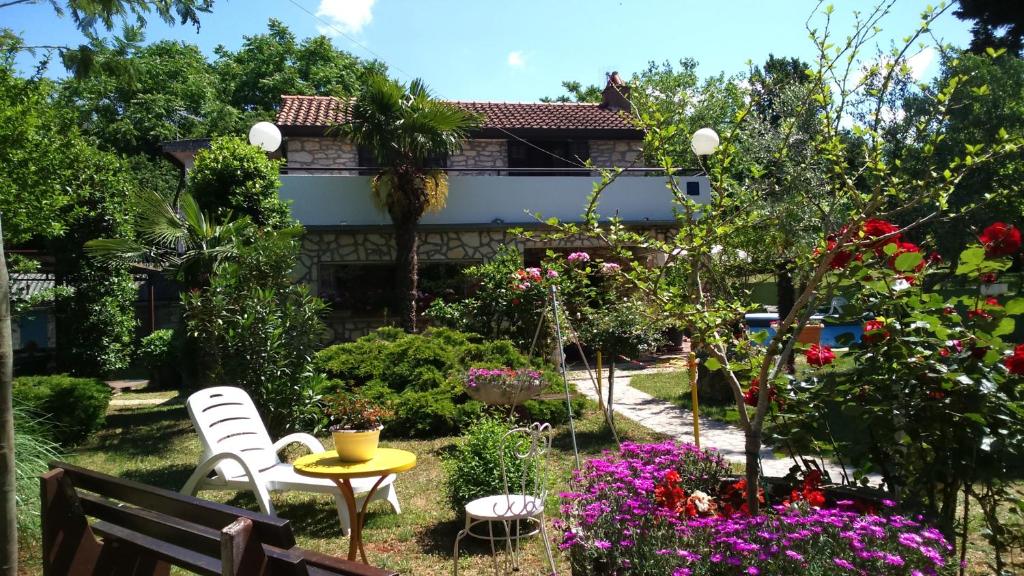 um jardim com mesa, cadeiras e flores em Apartments Rale em Umag