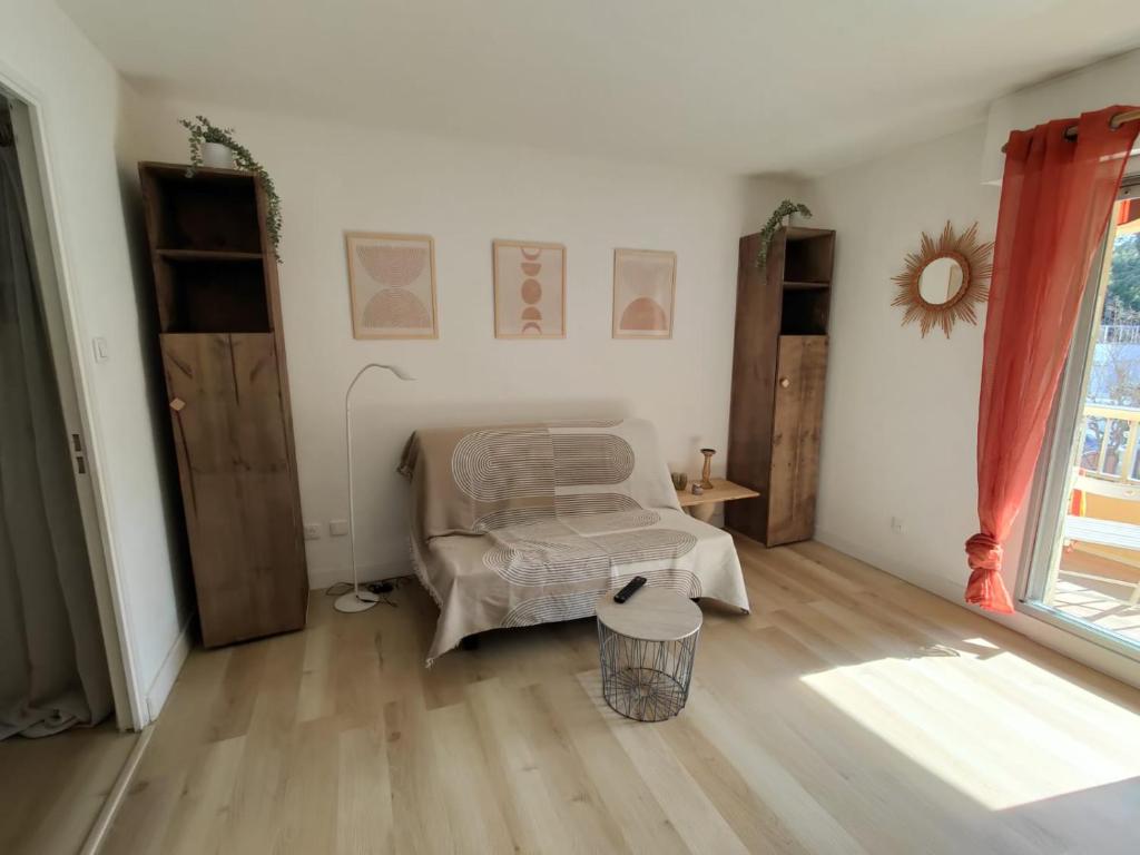 un salon avec une chaise et une table dans l'établissement Saint-Mandrier-sur-Mer Rsd Les comètes, à Saint-Mandrier-sur-Mer