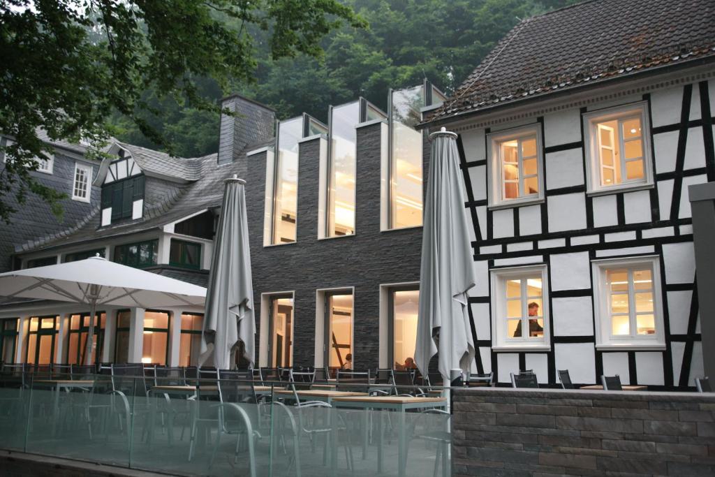 een gebouw met een patio met parasols bij Seminar- & Tagungshotel Große Ledder in Wermelskirchen
