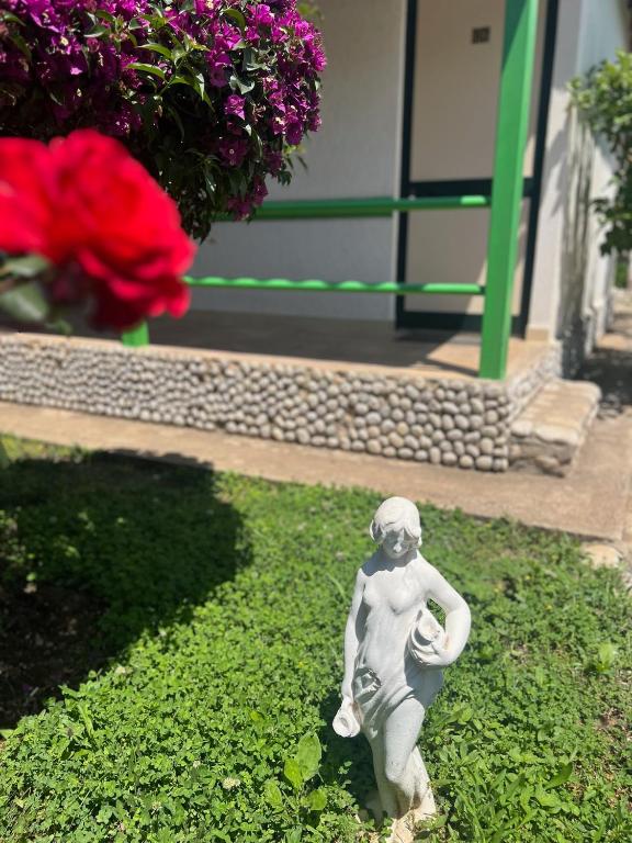 a statue of a little boy sitting in the grass at Chalet Ambel in Dhërmi