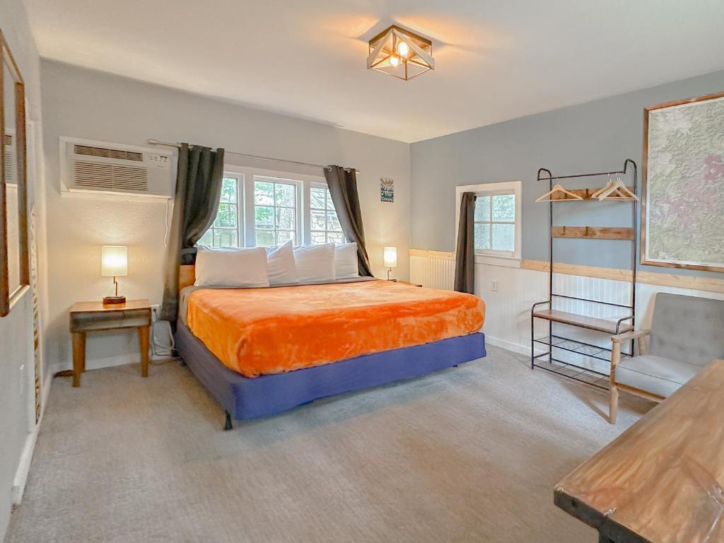 a bedroom with a bed and a chair and a table at The Wanderoo Lodge in Eureka Springs